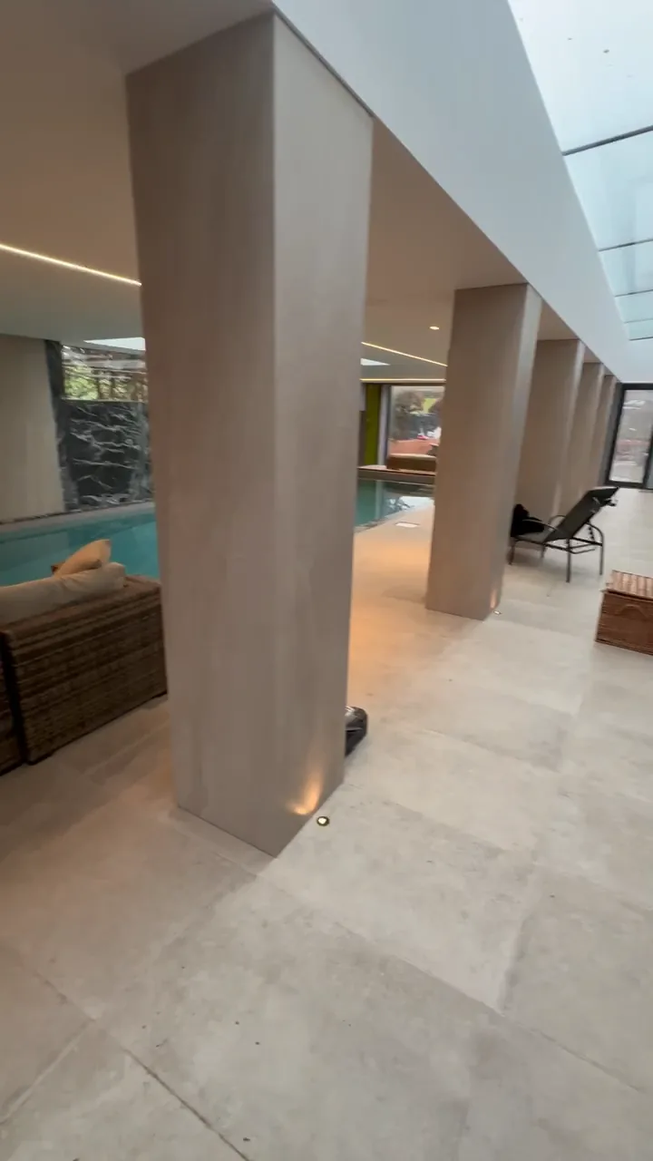 Second view of the same swimming pool room showing the underfloor heated stone surround