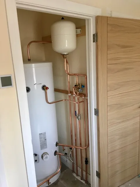 Unvented hot water cylinder installed alongside a system boiler