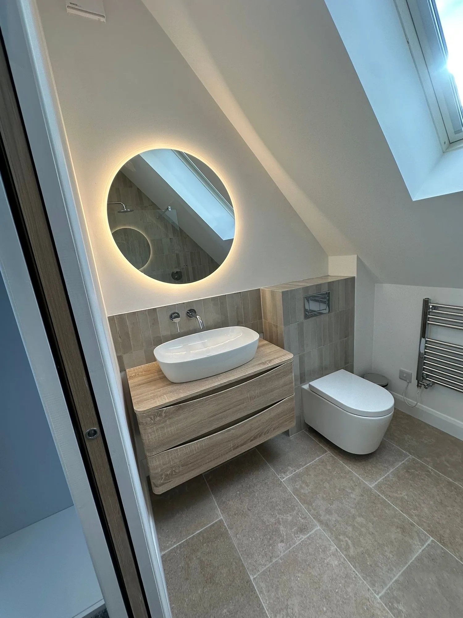Wall-hung vanity with vessel basin, backlit round mirror and wall-hung WC