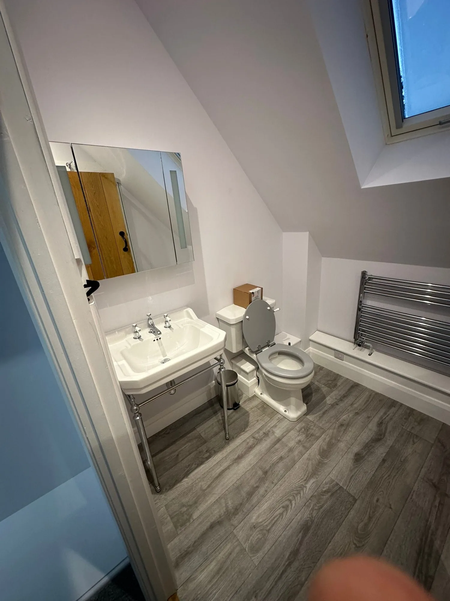Traditional loft ensuite with pedestal basin, close-coupled WC and chrome heated towel rail